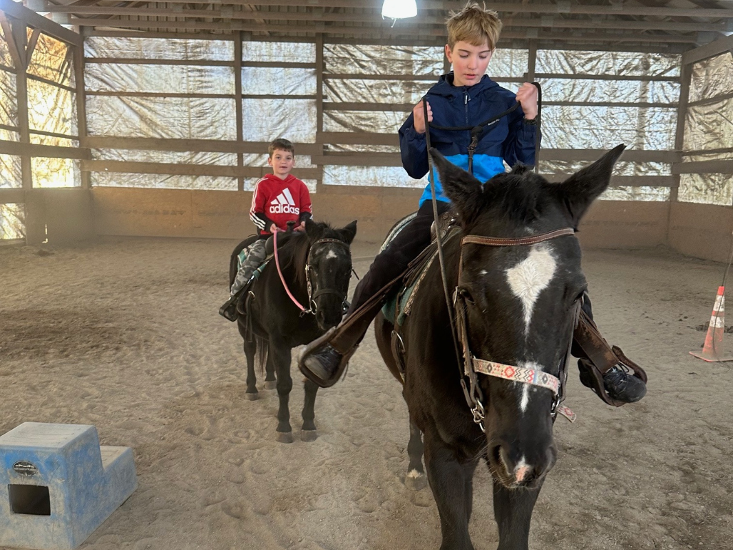 Boys confidently rides a horse